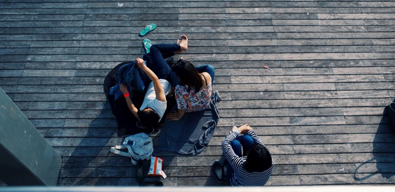 Ungdomar sitter ned på en altan, bilden tagen uppifrån 