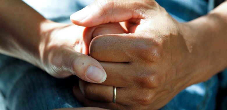 Två händer som håller hand inom vården